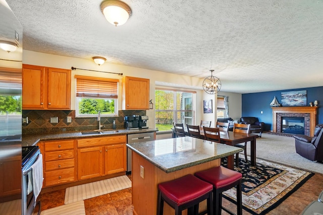 8380 Squad Dr, Galloway, OH 43119 - kitchen with a sink, stainless steel appliances, a center island, a chandelier, and brown cabinets
