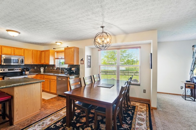 8380 Squad Dr, Galloway, OH 43119 - kitchen with appliances with stainless steel finishes, a sink, tasteful backsplash, a chandelier, and hanging light fixtures