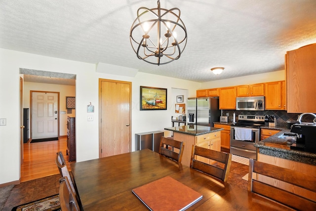 8380 Squad Dr, Galloway, OH 43119 - kitchen with appliances with stainless steel finishes, dark countertops, a sink, dark wood-style flooring, and tasteful backsplash