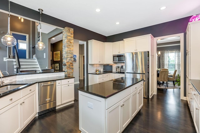 4166 Borge Way, Dublin, OH 43016 - kitchen featuring stainless steel appliances, a sink, ornate columns, dark wood finished floors, and tasteful backsplash