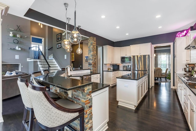 4166 Borge Way, Dublin, OH 43016 - kitchen featuring appliances with stainless steel finishes, a center island, dark countertops, a sink, and dark wood-style floors