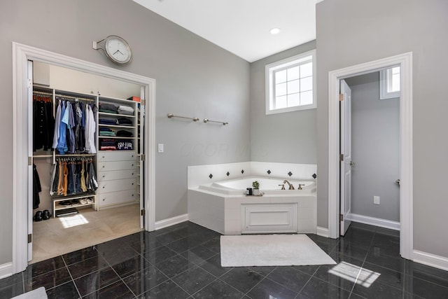 4166 Borge Way, Dublin, OH 43016 - bathroom featuring a garden tub, a spacious closet, baseboards, and granite tiled floors