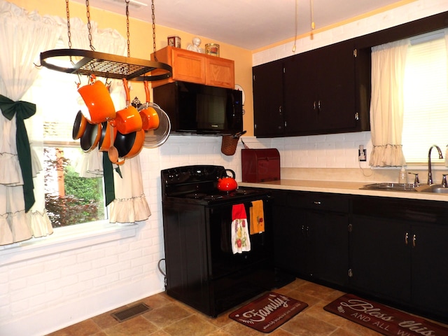 1202 W Mulberry St, Lancaster, OH 43130 - kitchen with black appliances, a sink, light countertops, decorative backsplash, and dark cabinetry