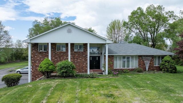 view of front of property featuring brick siding and a front lawn