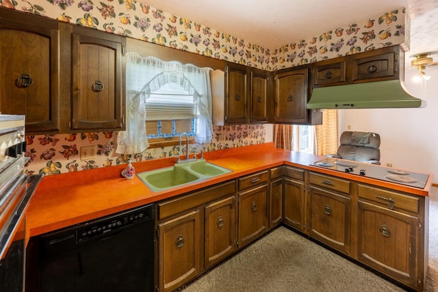kitchen with black appliances, wallpapered walls, a sink, healthy amount of natural light, and under cabinet range hood