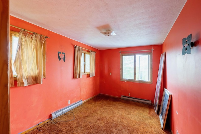 unfurnished room featuring baseboard heating, carpet floors, a textured ceiling, and baseboards