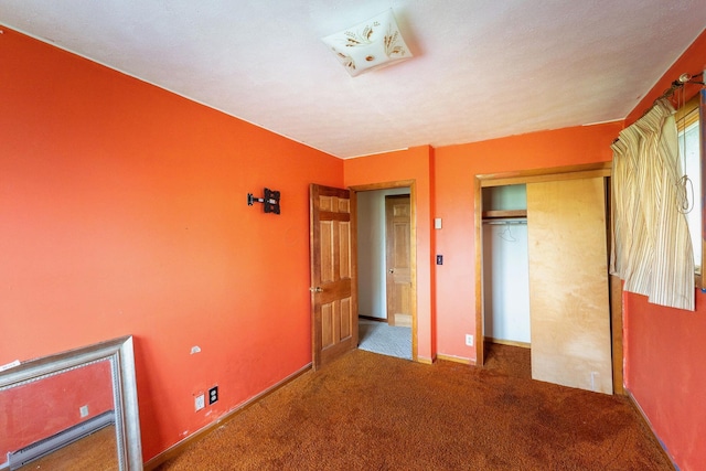 unfurnished bedroom featuring carpet flooring, a closet, and baseboards