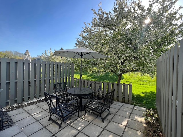 view of patio featuring outdoor dining space and fence