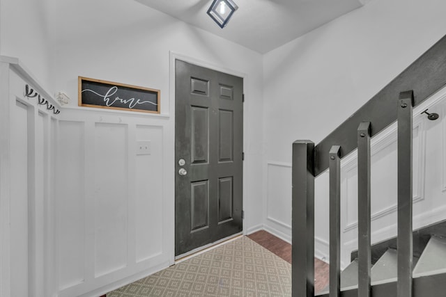 mudroom featuring a decorative wall and wainscoting