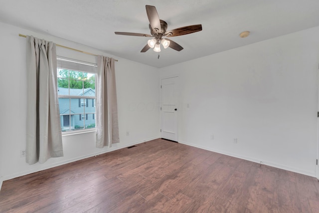 unfurnished room featuring wood finished floors, a ceiling fan, baseboards, and a smoke detector