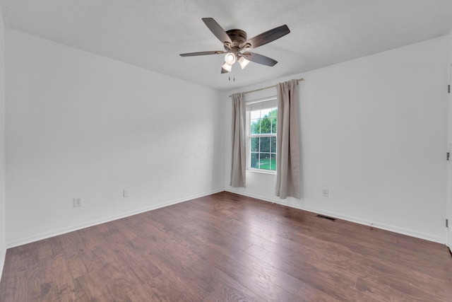 empty room featuring ceiling fan, wood finished floors, and baseboards