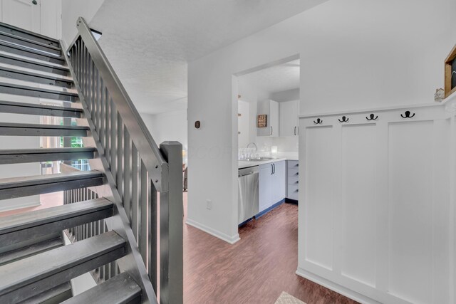 staircase with wood finished floors and baseboards