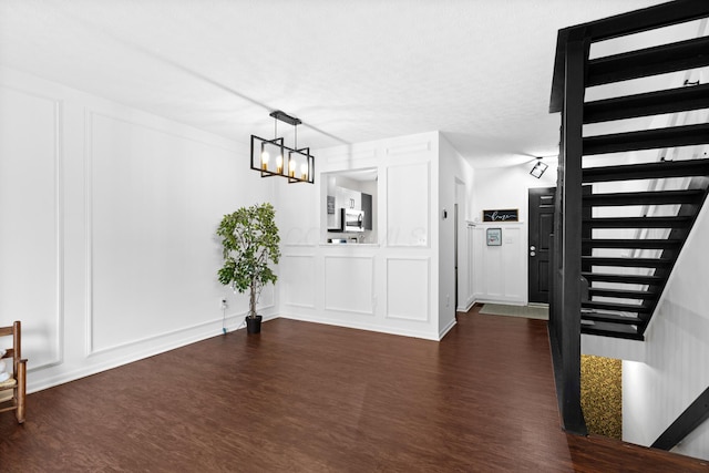 4102 Blendon Way Dr, Columbus, OH 43230 - unfurnished dining area with a decorative wall, stairs, dark wood-style floors, and a chandelier