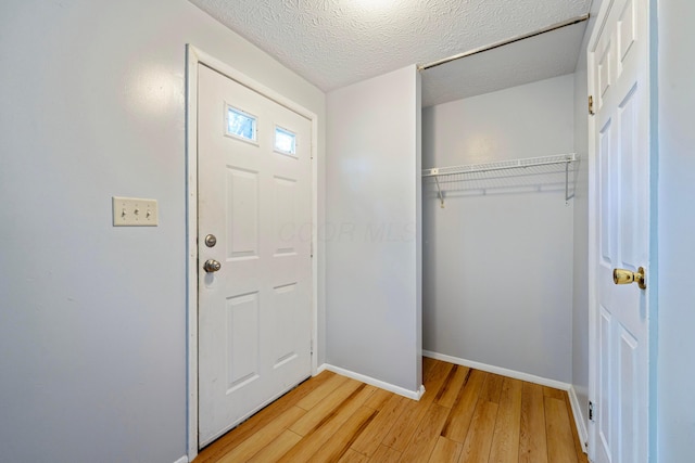 3860 Julia Ct, Columbus, OH 43230 - foyer entrance featuring light wood-type flooring, baseboards, and a textured ceiling