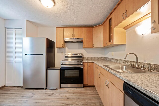 3860 Julia Ct, Columbus, OH 43230 - kitchen with stainless steel appliances, a sink, under cabinet range hood, light wood finished floors, and a textured ceiling