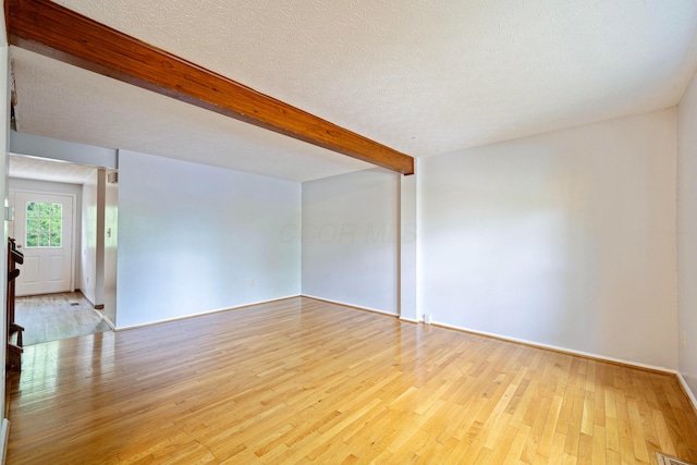 3860 Julia Ct, Columbus, OH 43230 - unfurnished room featuring light wood finished floors, beamed ceiling, a textured ceiling, and baseboards