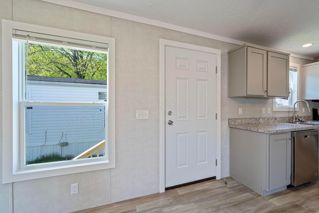 kitchen featuring gray cabinets, dishwasher, light wood-style floors, light countertops, and a textured ceiling