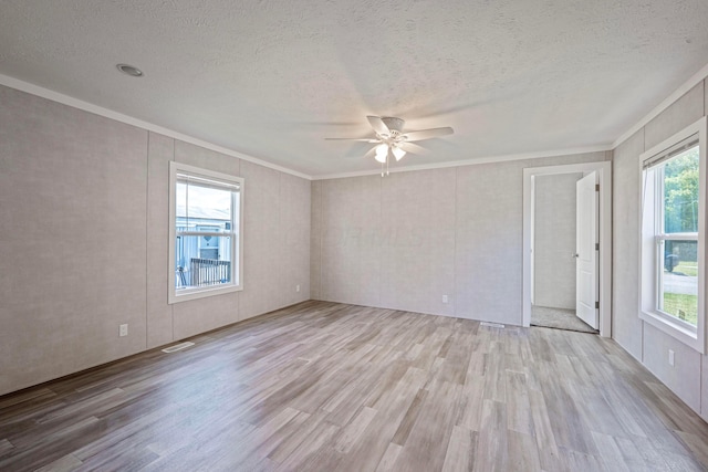 empty room with ornamental molding, wood finished floors, ceiling fan, and a textured ceiling