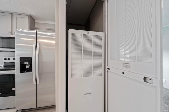 kitchen view of appliances with stainless steel finishes and a heating unit