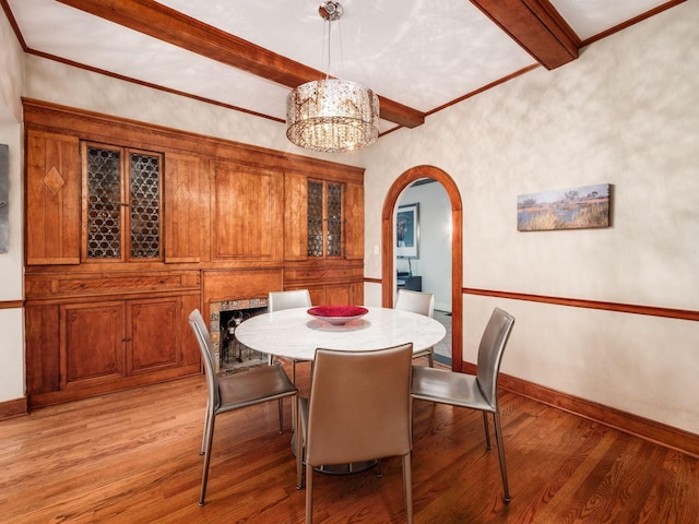 10 Park Dr, Columbus, OH 43209 - dining space featuring arched walkways, beam ceiling, light wood-style flooring, a chandelier, and baseboards