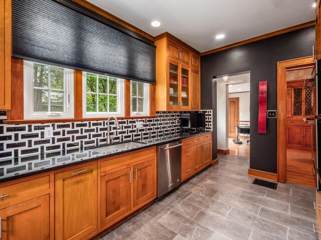 10 Park Dr, Columbus, OH 43209 - kitchen featuring stainless steel dishwasher, a sink, brown cabinets, backsplash, and glass insert cabinets