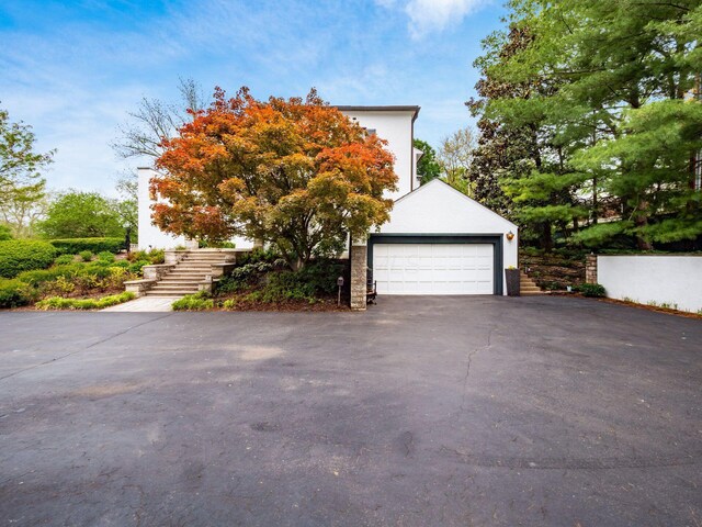 10 Park Dr, Columbus, OH 43209 - view of side of property featuring stairway, a garage, and asphalt driveway