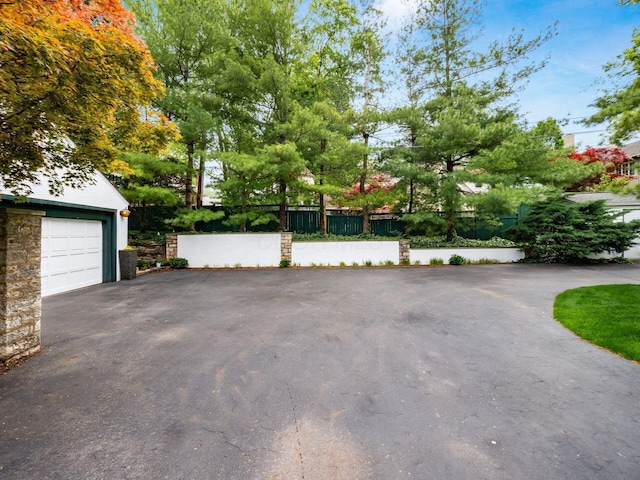 10 Park Dr, Columbus, OH 43209 - view of property exterior with driveway, a garage, fence, and stone siding