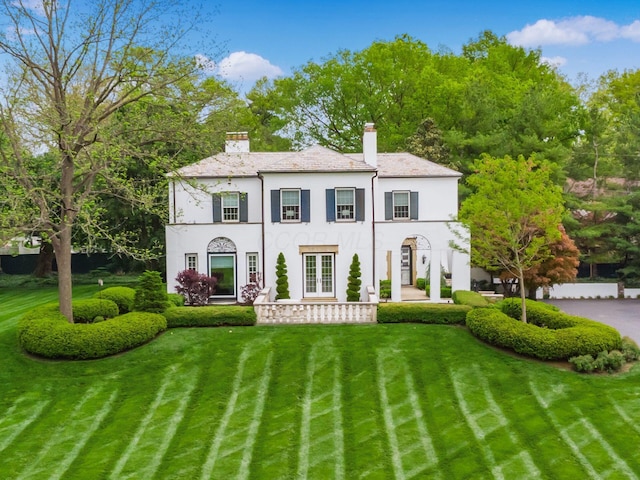 10 Park Dr, Columbus, OH 43209 - view of front of house with stucco siding, a chimney, a front lawn, and french doors