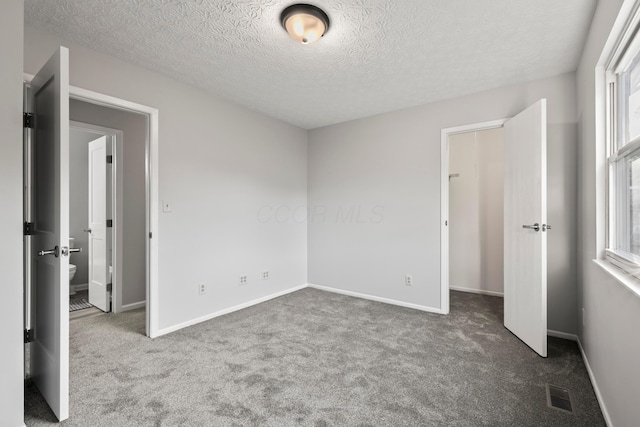 2458 Dunsworth Dr, Columbus, OH 43235 - unfurnished bedroom with carpet floors, multiple windows, a textured ceiling, and baseboards