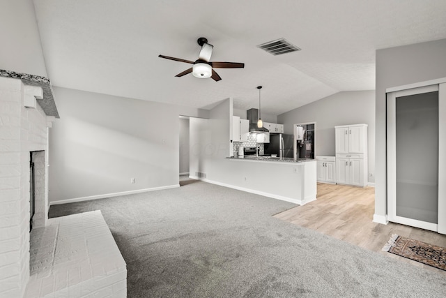 2458 Dunsworth Dr, Columbus, OH 43235 - unfurnished living room featuring ceiling fan, light colored carpet, vaulted ceiling, baseboards, and a fireplace