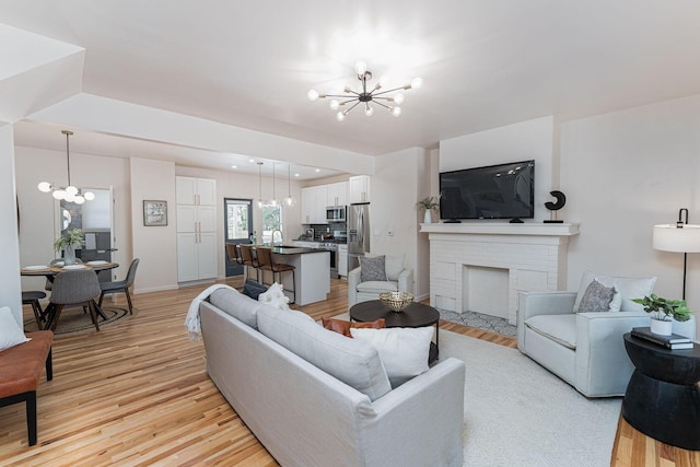 549 Hanford St, Columbus, OH 43206 - living room featuring a chandelier, light wood finished floors, and a fireplace