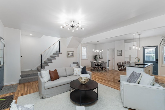 549 Hanford St, Columbus, OH 43206 - living area with a chandelier, light wood-style flooring, stairs, and baseboards