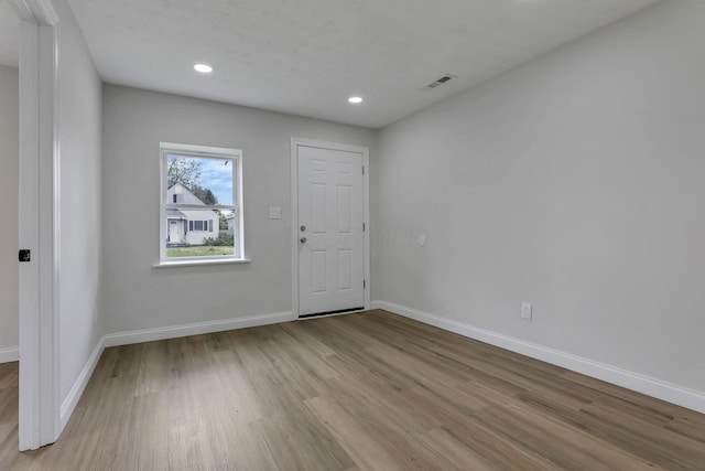 foyer featuring wood finished floors, baseboards, and recessed lighting