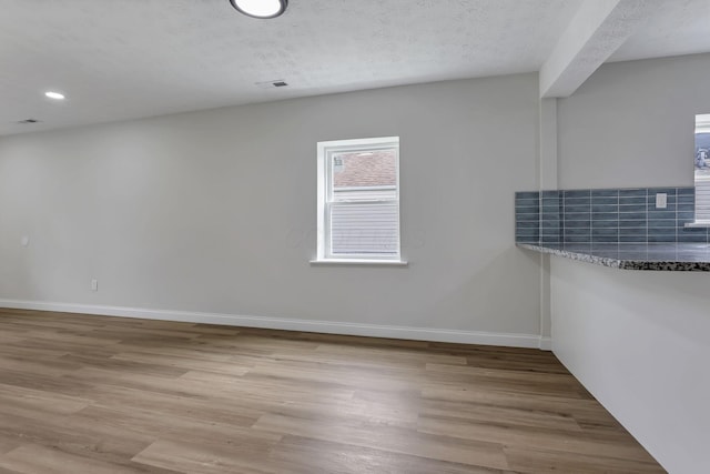 spare room featuring light wood-style flooring, baseboards, and recessed lighting