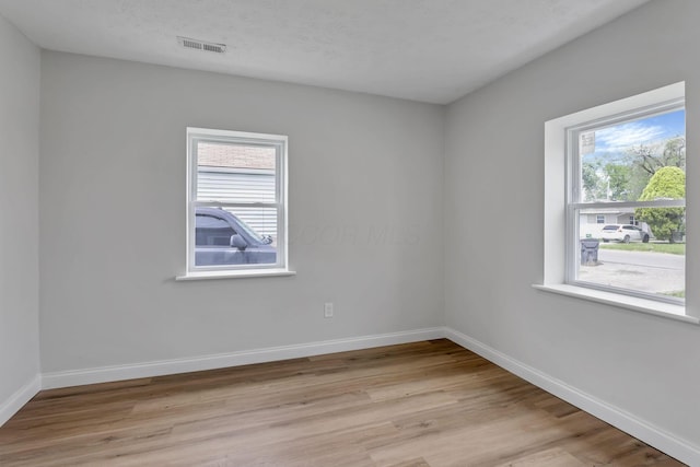 spare room featuring light wood-type flooring and baseboards