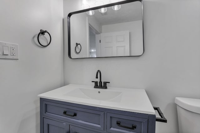 half bathroom with vanity and toilet