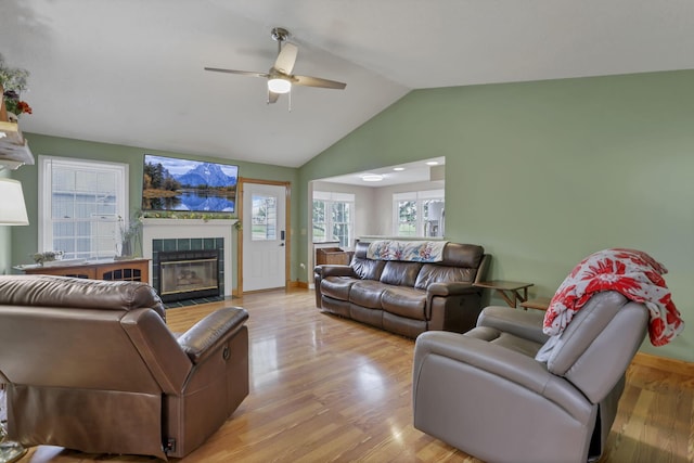 11708 Broad St, Millersport, OH 43046 - living area with a ceiling fan, a tiled fireplace, vaulted ceiling, light wood-type flooring, and baseboards