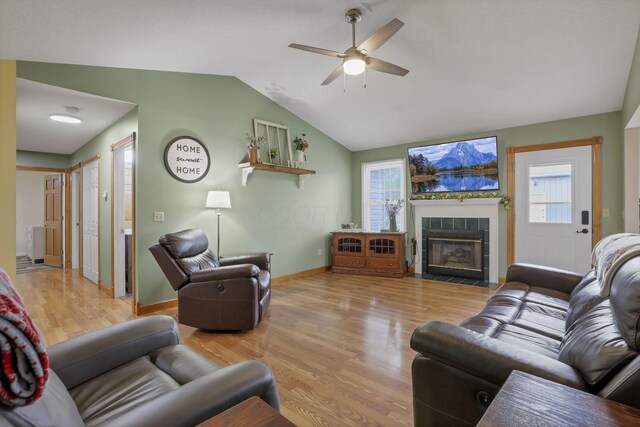 11708 Broad St, Millersport, OH 43046 - living area featuring ceiling fan, wood finished floors, a tile fireplace, plenty of natural light, and vaulted ceiling