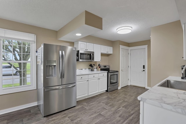 11708 Broad St, Millersport, OH 43046 - kitchen with appliances with stainless steel finishes, a sink, a textured ceiling, baseboards, and dark wood-style flooring