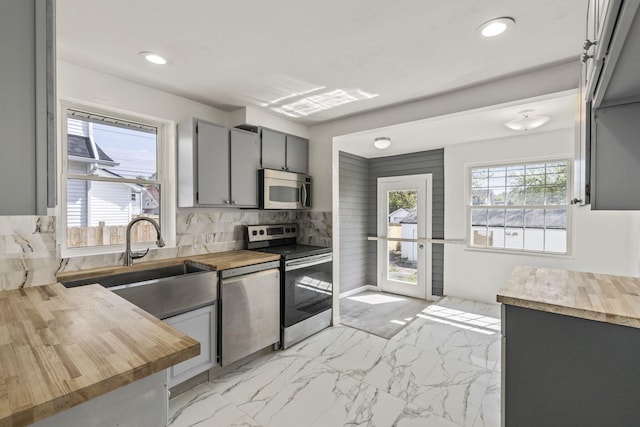 436 Nashoba Ave, Columbus, OH 43223 - kitchen with wooden counters, stainless steel appliances, gray cabinetry, decorative backsplash, and light marble finish floors