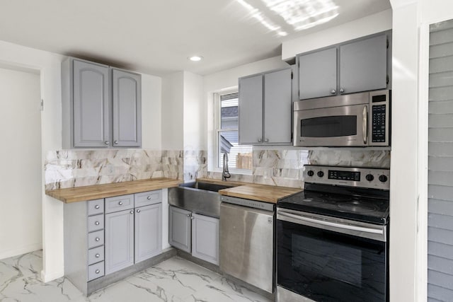 436 Nashoba Ave, Columbus, OH 43223 - kitchen with appliances with stainless steel finishes, gray cabinetry, butcher block countertops, light marble finish flooring, and recessed lighting
