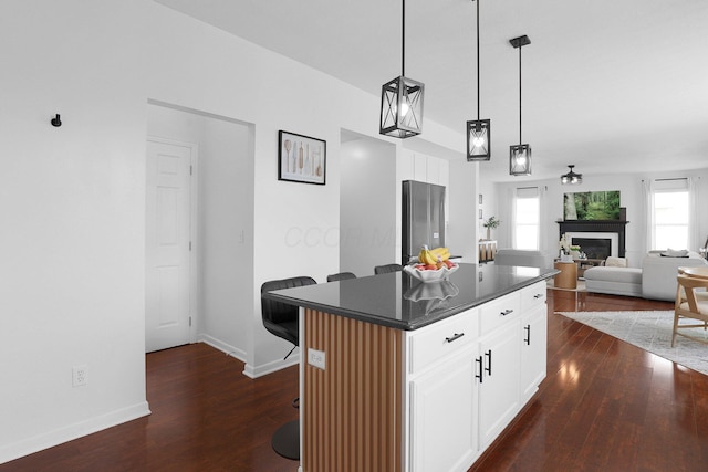 210 Carson Ct, Pickerington, OH 43147 - kitchen with dark countertops, dark wood-type flooring, a kitchen island, and a kitchen bar