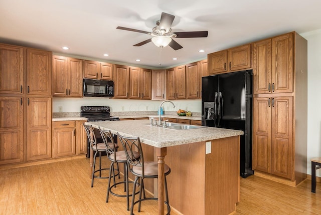 1380 E Choctaw Dr, London, OH 43140 - kitchen with black appliances, a sink, a ceiling fan, light countertops, and light wood-style flooring