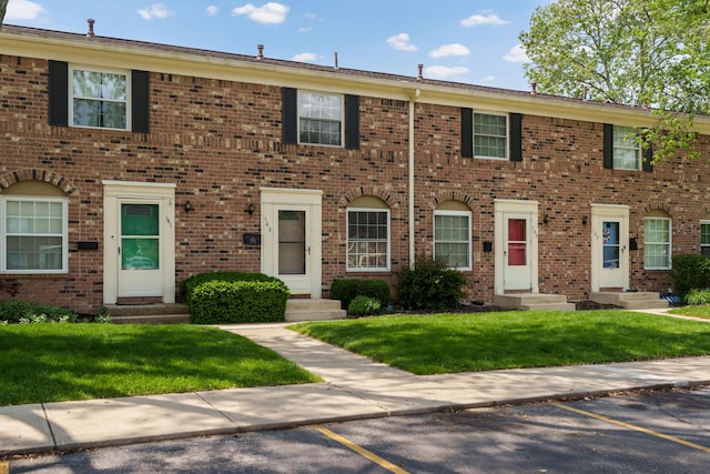 143 Tarryton Ct W Unit 24E, Columbus, OH 43228 - view of property with uncovered parking, brick siding, entry steps, and a front yard