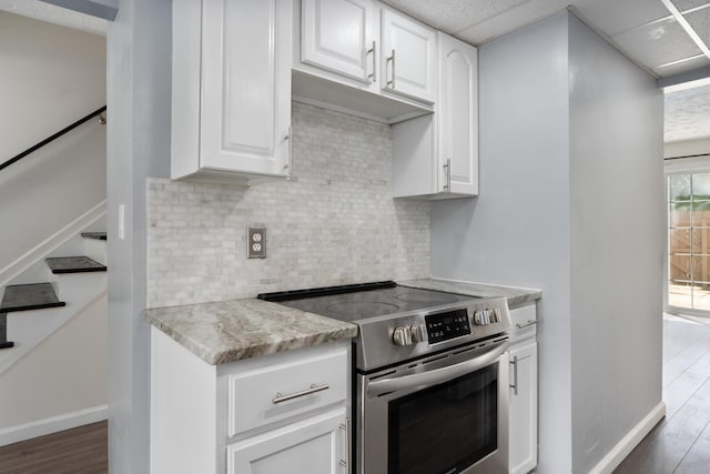 143 Tarryton Ct W Unit 24E, Columbus, OH 43228 - kitchen featuring electric range, baseboards, decorative backsplash, white cabinetry, and wood finished floors