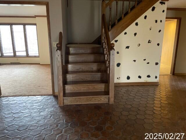 stairway with carpet floors, baseboards, and crown molding