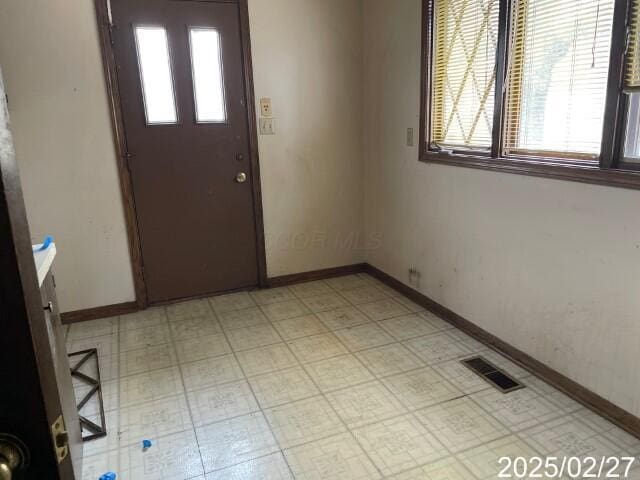 foyer entrance featuring baseboards and light floors