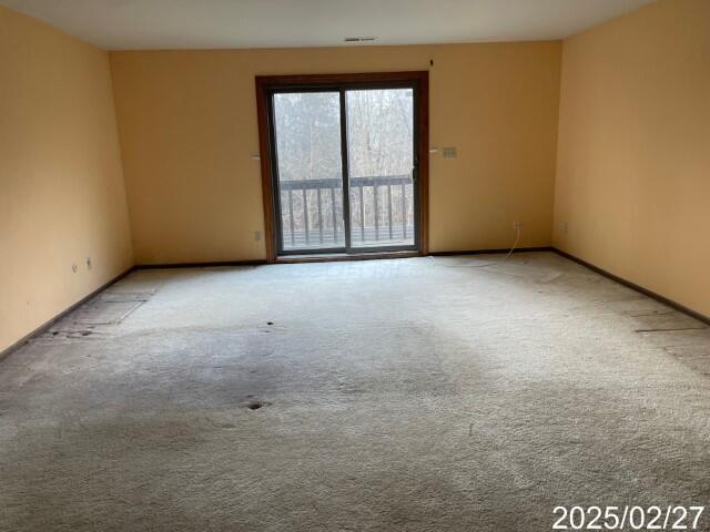 carpeted empty room with baseboards
