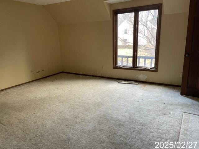 bonus room featuring light carpet, vaulted ceiling, and baseboards