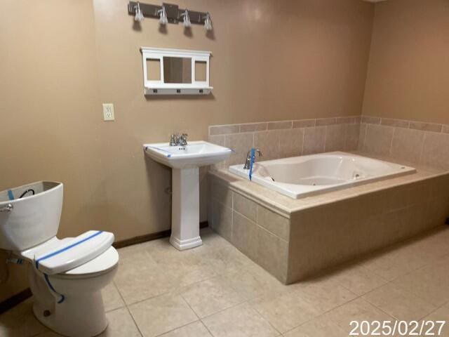 full bathroom featuring tile patterned flooring, a garden tub, toilet, and a sink